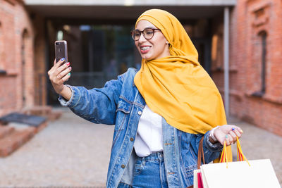 Man holding mobile phone while standing on camera