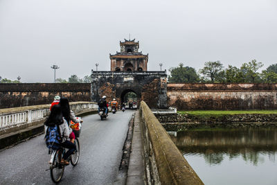 People on bridge against sky