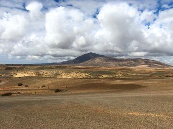 Scenic view of field against cloudy sky