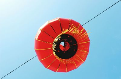 Low angle view of red umbrella against clear sky