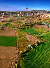 View of hot air balloons on field against sky