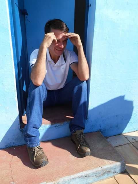 FULL LENGTH OF MAN SITTING ON BLUE CHAIR