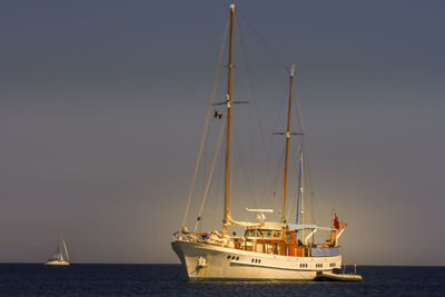 Sailboat sailing on sea against clear sky