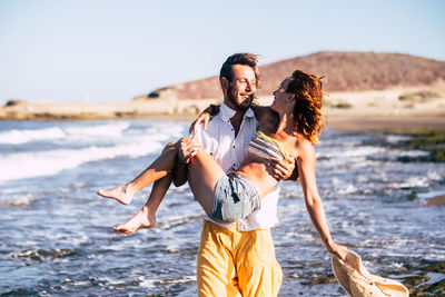 Rear view of man and woman standing on beach