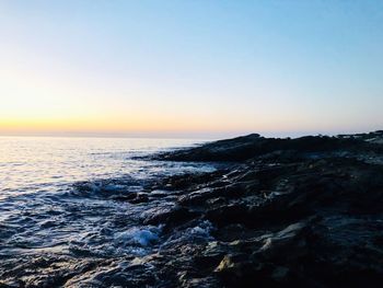 Scenic view of sea against clear sky during sunset