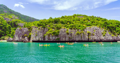 Scenic view of sea by mountain against sky