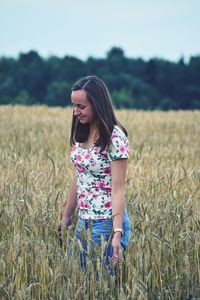 Young woman walking on grassy field