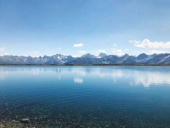 Scenic view of lake and mountains against blue sky