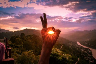 Sun shining over mountain against sky during sunset