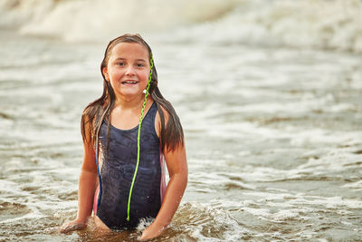 Portrait of young woman standing at beach