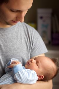 Midsection of man holding newborn baby