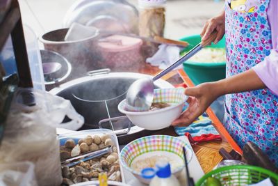 Midsection of man preparing food at market stall