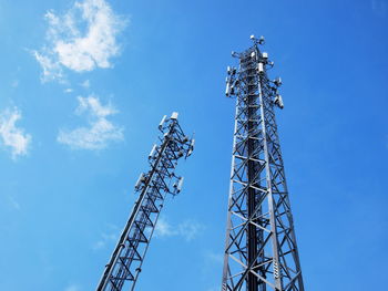 Low angle view of communications tower against blue sky