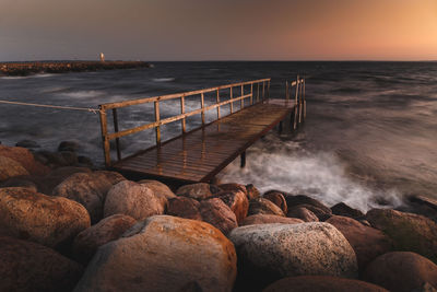 A jetty on the coast of southern sweden. to the left is the harbor. in the sunset.