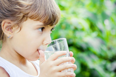 Close-up of young woman drinking milk in park