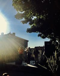 People standing by buildings against sky