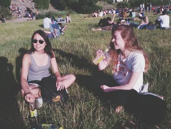 Friends standing on grassy field