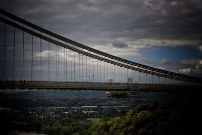 View of suspension bridge against cloudy sky