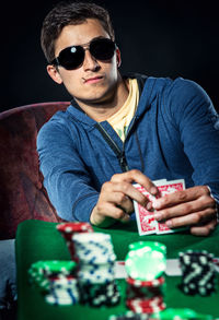 Man playing poker against black background