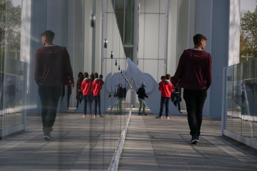 REAR VIEW OF PEOPLE WALKING ON CORRIDOR