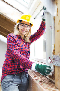 Portrait of smiling woman working at construction site