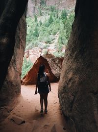 Rear view of man and woman walking in cave