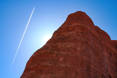 Low angle view of rock formation against clear blue sky