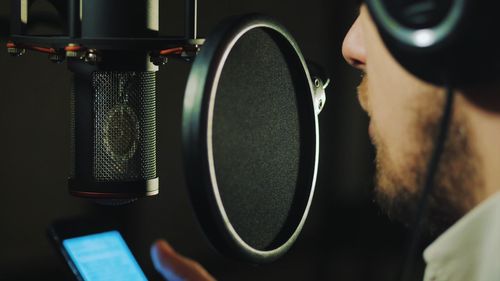 Close-up of man singing at recording studio