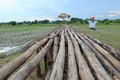 Wooden structure on field against sky