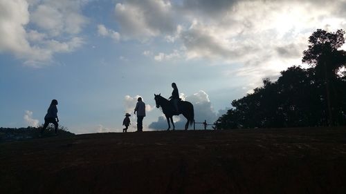 Silhouette people on field against sky