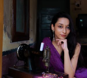 Portrait of woman sitting on table at home