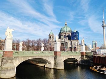 Arch bridge over river against buildings in city