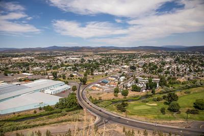 High angle view of street amidst field against sky