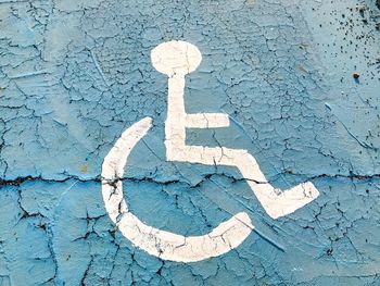 Close-up of disabled sign on weathered wall