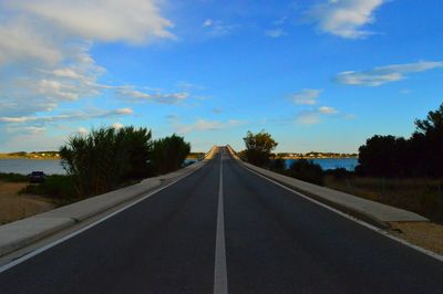 Empty road against cloudy sky