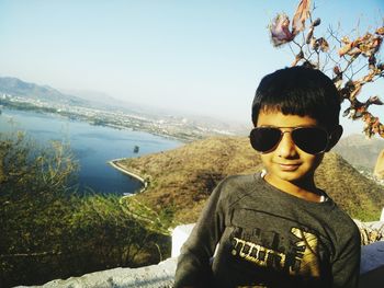 Portrait of boy standing against river