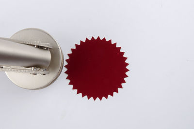 Close-up of equipment with red seal over white background