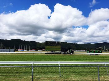 Scenic view of grassy field against cloudy sky