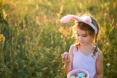 Portrait of cute girl wearing hat standing on field