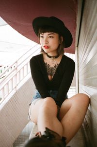 Beautiful young woman sitting on table