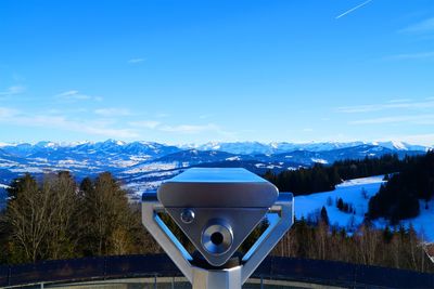 Scenic view of snow covered mountains against blue sky