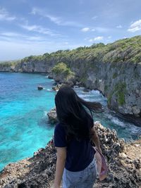 Rear view of woman looking at sea against sky