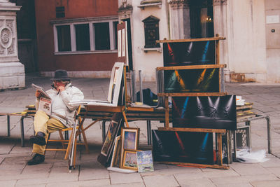 Man sitting on chair against building