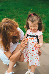 Full length of cute girl holding mother and daughter