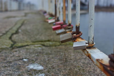 Close-up of rusty metal fence on footpath