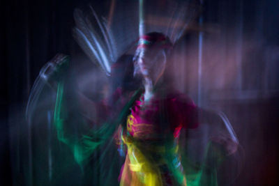 Digital composite image of woman with light painting at night