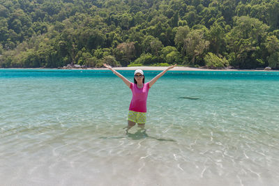 Woman standing on beach against sky