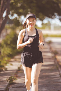 Portrait of beautiful woman standing on footpath