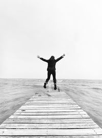 Full length rear view of man on sea against sky