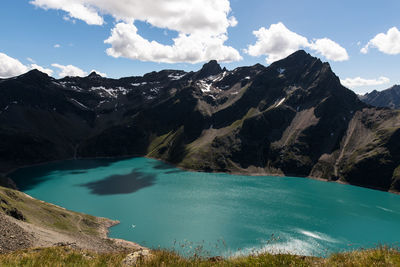 Scenic view of river and mountains against sky